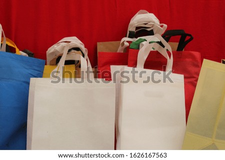 white color Valentine Day Shopping Bags on red background. non woven Gift bags. eco friendly Grocery Bags. Reduce, Reuse, Recycle, save earth. World Environment Day