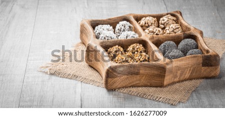 Energy protein balls with healthy ingredients. Home made with dried apricots, dates, plum, almonds, walnuts, sunflower seeds covered with cocoa powder, sesame, coconut flakes
