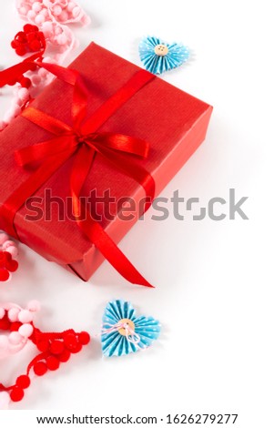 Red gift box with heart and bow on white background. Valentines day 14 february packaging concept.