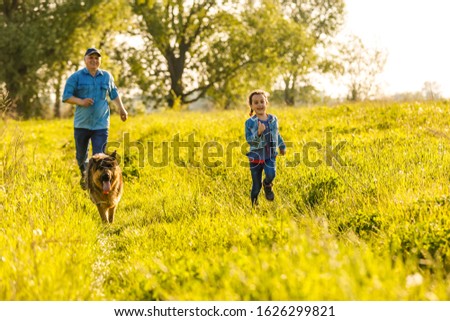 Little girl with dog running on the road