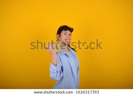 woman at the cinema with popcorn on a yellow background