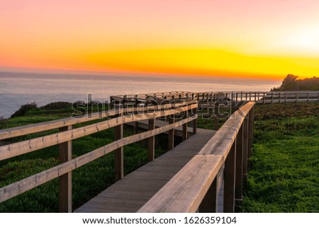 Wooden path at sunset along the ocean, Portugal.
