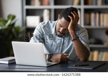 Tired bored african american businessman employee falling asleep at work sitting at office desk, sleepy exhausted male student worker sleeping at workplace near laptop, lack or sleep overwork concept