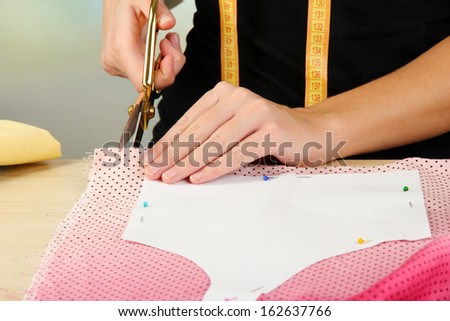 Cutting fabric with tailors scissors 