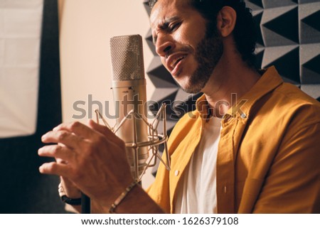 Man passionately singing in recording studio