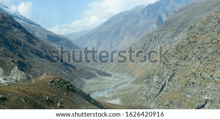 V-shaped Himalayas valley down which a river with a winding course flows. An interlocking overlapping spur hill ridges V-shaped valley that extends into a concave bend from opposite side of riverbank. Royalty-Free Stock Photo #1626420916