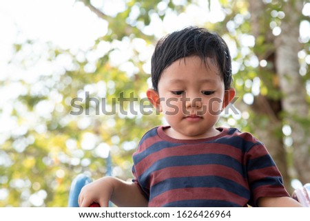 Asian little boy portrait playing in the Park on the Playground for Kids & Children with Slides, Swings, Climbing