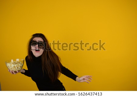 young woman in 3D glasses holds popcorn in her hands watching a movie emotions place free