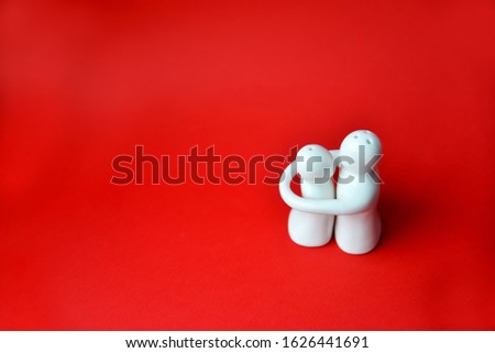 
white figures in a hug on a red background. valentines day concept