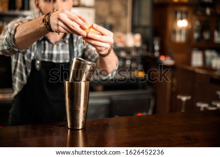 Cropped photo of professional barman breaking an egg into shaker stock photo