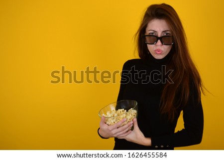 woman in black clothes with popcorn in her hands watching a movie isolated background