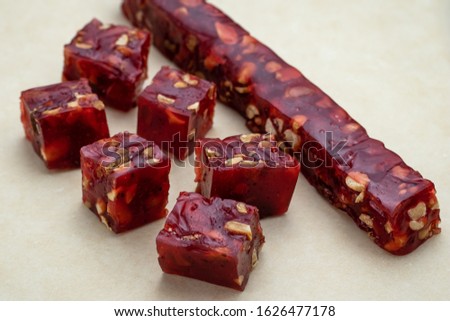 A chips of churchkhela on brown craft paper. Confectionery with grape and nuts. Red churchela. Traditional Georgian cuisine.