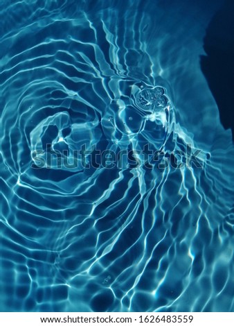 Abstract​ of​ surface​ blue​ water​ reflected​ by​ sunlight​ on​ the​ deep​ sea. Blue water​ in the​ deep​ sea​ for​ background​