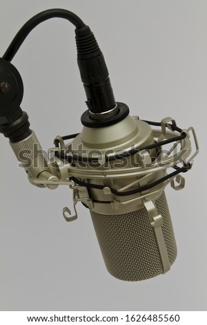 professional microphone with black cable mounted in a microphone spider