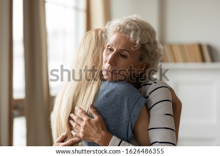 Young empathic woman embracing soothing comforting frustrated older mature mother. Grownup daughter apologizing to offended middle aged mommy. Two female generations family overcoming grief together. Royalty-Free Stock Photo #1626486355