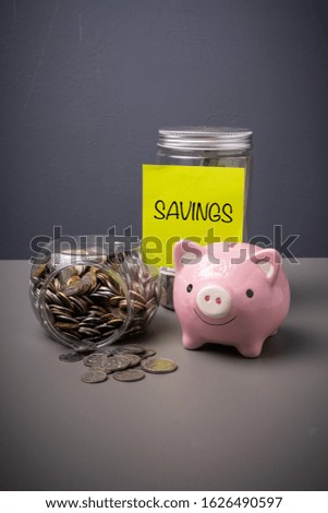 SAVINGS wording on a paper with jar full of coins. 