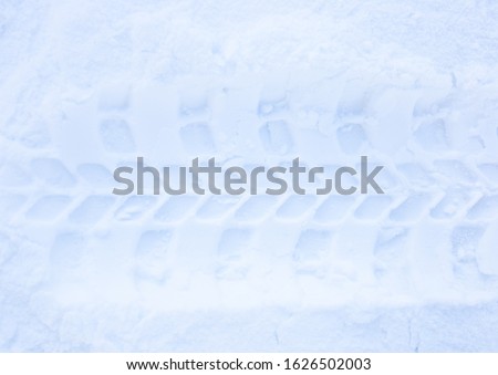 trace of car tire on winter road in snow background