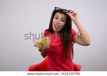 young woman in t-shirt sitting on the chair with popcorn movie