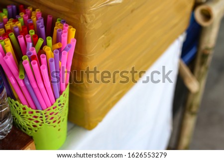 Colorful plastic Straws in street food restaurant. Soft picture