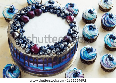 Bright festive blue cake with berries and chocolate and cupcakes with cream, candy bar, Sweet bar