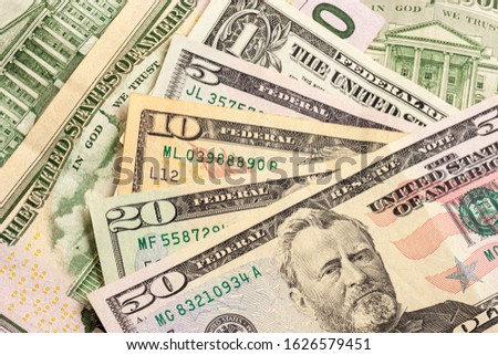 Texture of multiple US dollar banknotes. Background from paper money. A few dollars of varying nominal values. USA dollar bills. Close-up of multiple American dollar greenbacks. Royalty-Free Stock Photo #1626579451