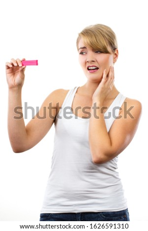 Unhappy worried shocked woman looking at pregnancy test with positive result, checking pregnancy test, unwanted pregnancy