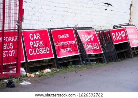 Car park closed ramp ahead danger construction traffic collection of red danger signs in a row within builders yard