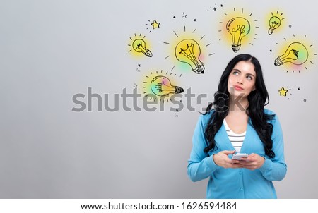 Idea light bulbs with thoughtful young woman holding a smartphone