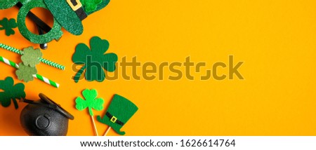 Saint Patrick's Day background with clovers shamrock symbols, Irish elf hats, pot, party drinking straws. Happy St. Patrick’s Day concept. Greeting card, party invitation template, banner mockup
