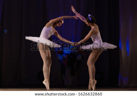 Young girls ballerina in a white tutu costume dancing ballet performance on stage in a theater