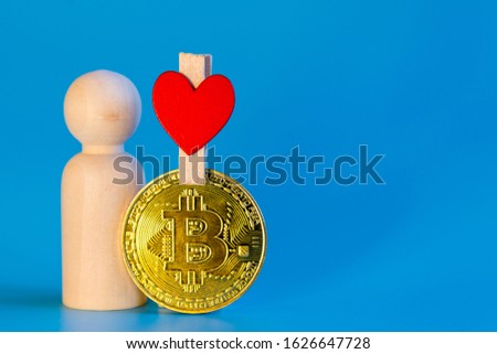 Human figurine, bitcoin coin and heart on a blue background. love for cryptocurrency concept. copy space