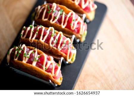 Ahi tuna tacos. Tuna tacos served in crispy shells with spicy wasabi sauce, avocado sliced and shisito leaves. Classic Japanese restaurant or American steakhouse appetizer favorite. Royalty-Free Stock Photo #1626654937