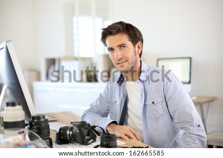 Photographer in office working on desktop computer