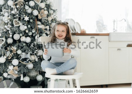 Happy little girl receives gifts. Holidays.