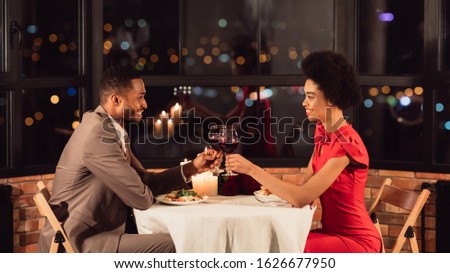 Cheers To Love. Happy Black Spouses Clinking Glasses Drinking Red Wine Celebrating Valentine During Romantic Dinner In Restaurant. Panorama