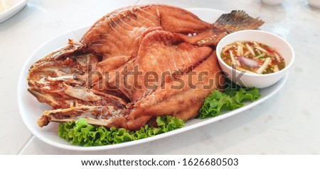 Deep fried fish with fish sauce eated with sliced mango, dried shrimp, and chili with sweet and sour sauce Royalty-Free Stock Photo #1626680503