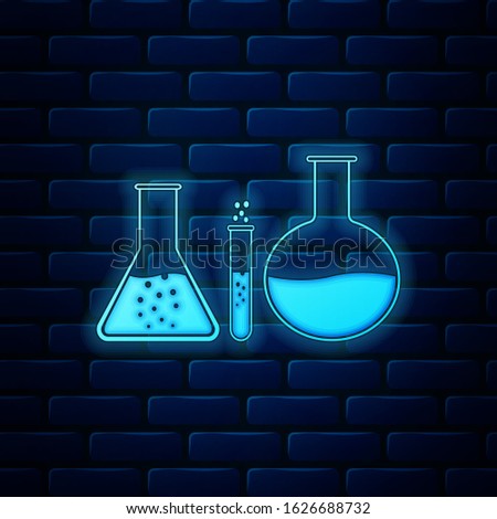 Glowing neon Test tube and flask - chemical laboratory test icon isolated on brick wall background. Laboratory glassware sign