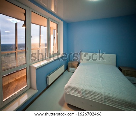 interior of a modern large blue room with a large bed