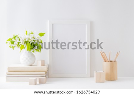 Home interior with decor elements. Mockup with a white frame, spring flowers in a vase on a light background
