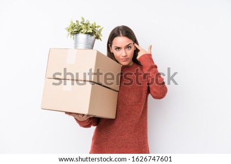 Young caucasic woman holding boxes isolated pointing temple with finger, thinking, focused on a task.
