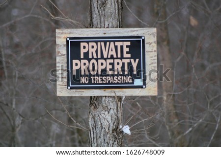 No Trespassing sign posted for rural wooded property, winter, snow
