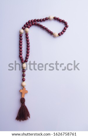 Wooden christian rosary with a cross. White isolated background.