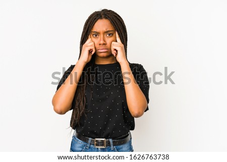 Young african american woman isolated on white background focused on a task, keeping forefingers pointing head.