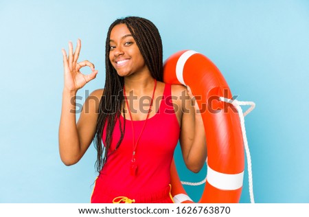 Young african american life guard woman isolated cheerful and confident showing ok gesture.