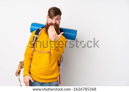 Young mountaineer man with a big backpack over isolated white background inviting to come