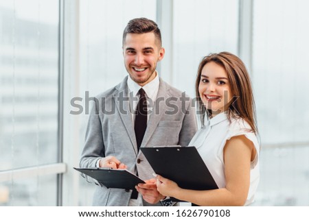 Candid shot of happy successful businesspartners wearing formal clothing and cheering, congratulating profitable deal.