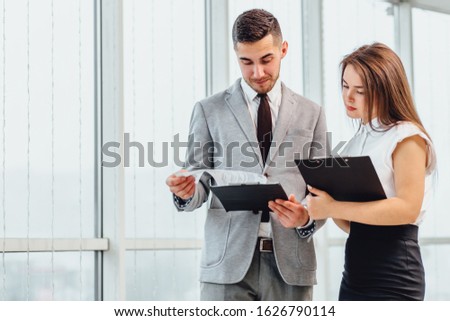 Successful man and woman making business plan, comparing each other researches.