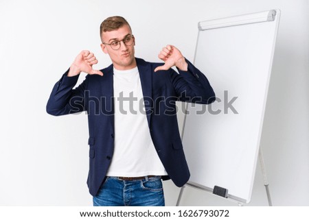 Young coaching man showing a white board feels proud and self confident, example to follow.