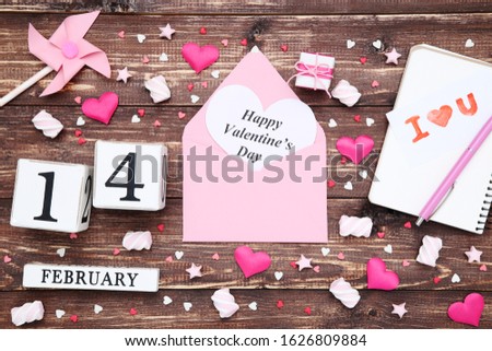 Valentine hearts with cube calendar, marshmallows and text Happy Valentines Day on wooden table
