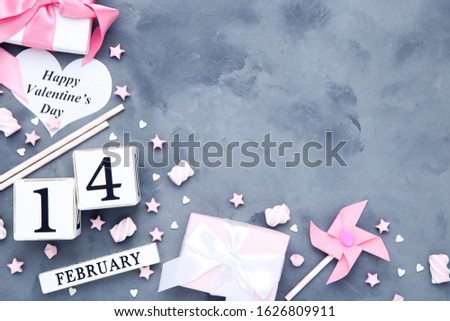 Cube calendar with gift boxes, marshmallows and paper stars on grey background